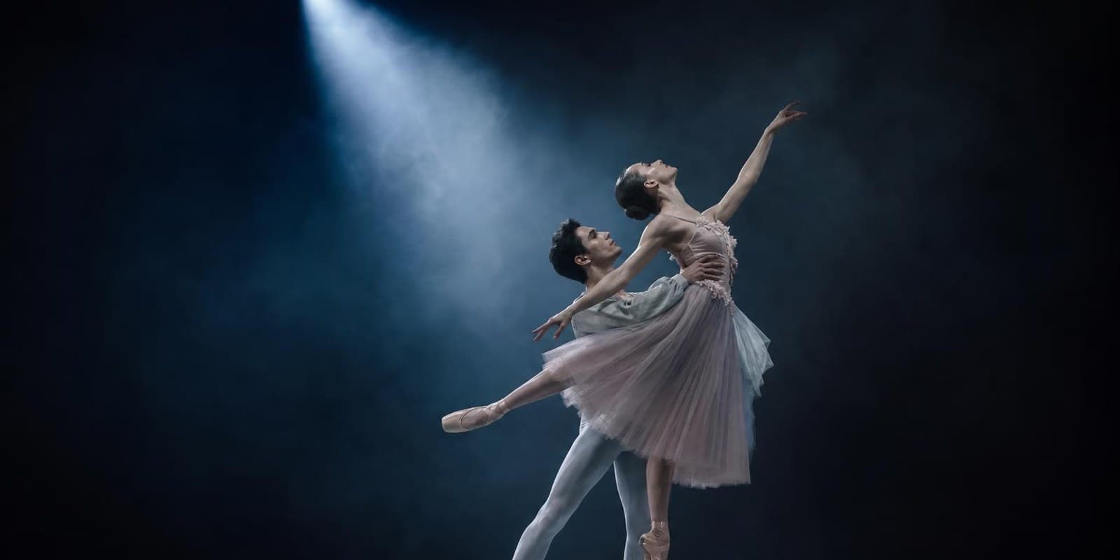 Aquarell: zwei Balletttaenzer in fliessender Bewegung im Lichtkegel der Buehne.