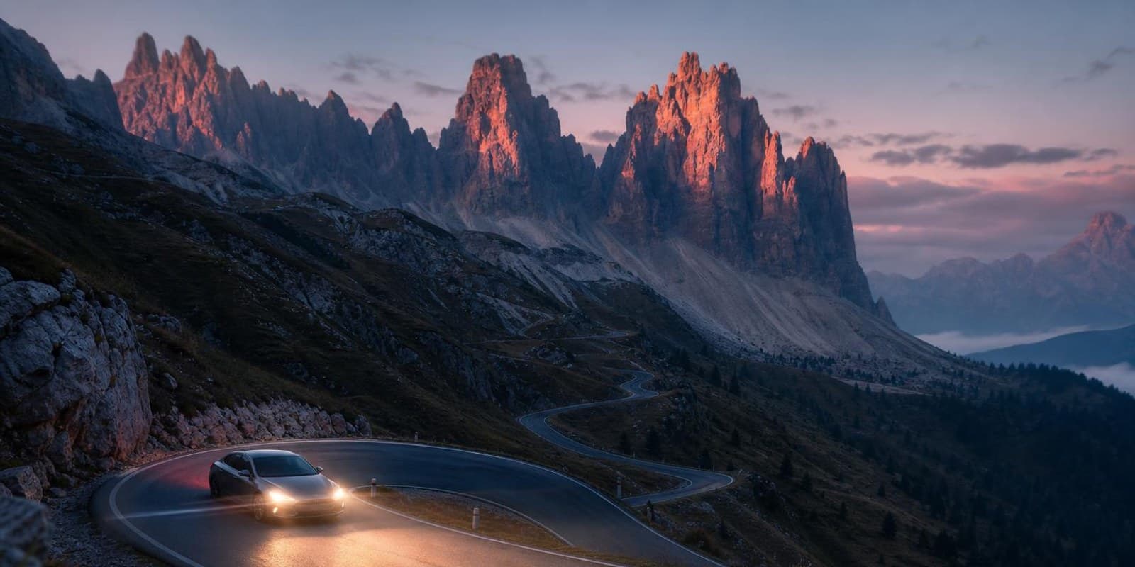 Serpentinenstrasse windet sich im Morgenlicht unter schroffen Dolomitengipfeln.