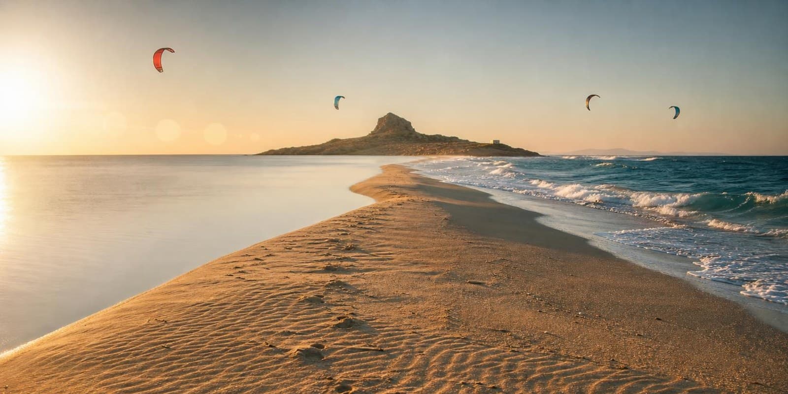 Schmale Sandzunge von Prasonisi trennt flaches Wasser und Wellen, auf beiden Seiten fliegen Kites.
