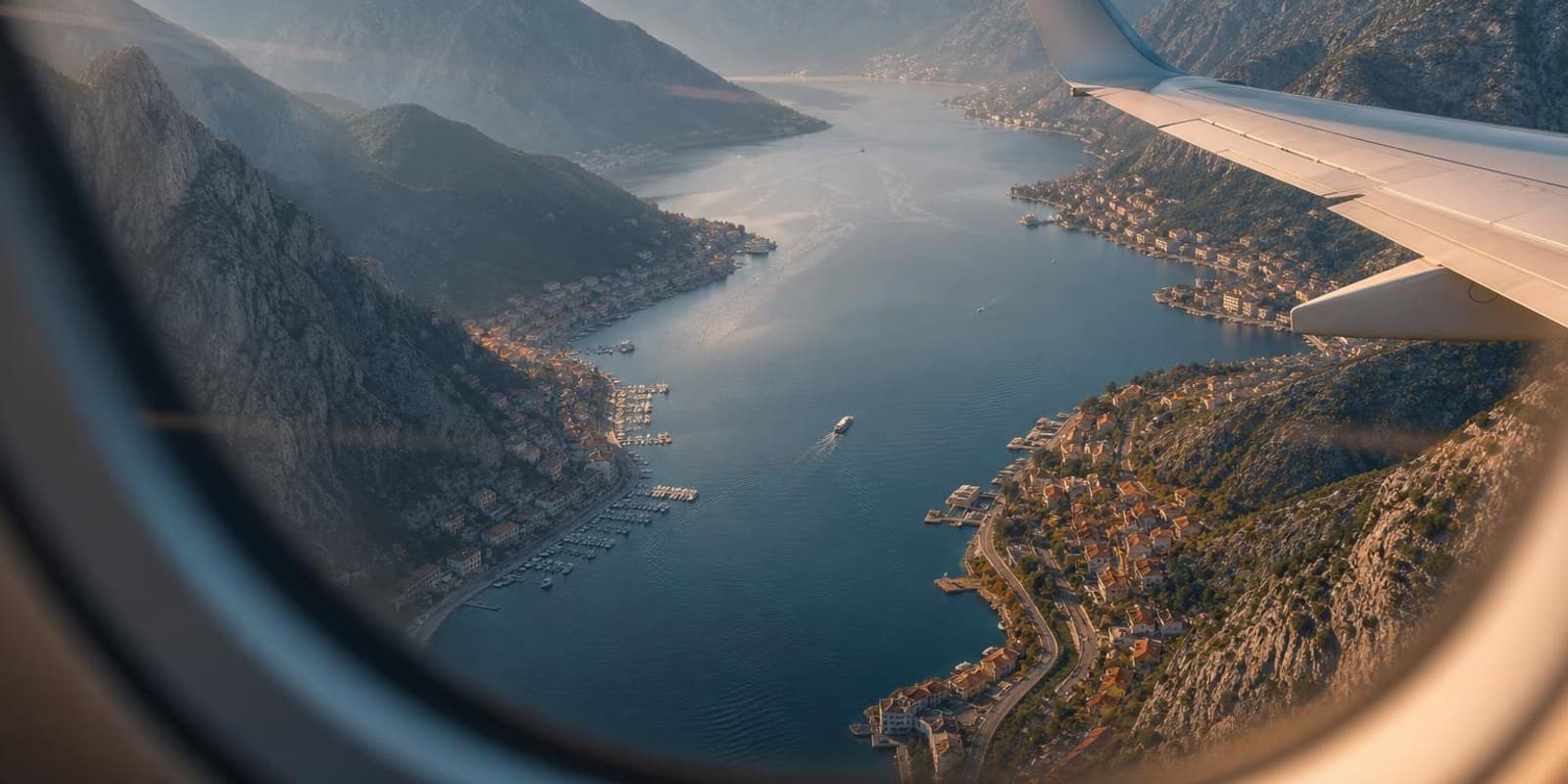 Blick aus dem Flugzeugfenster auf die fjordartige Bucht von Kotor beim Anflug.