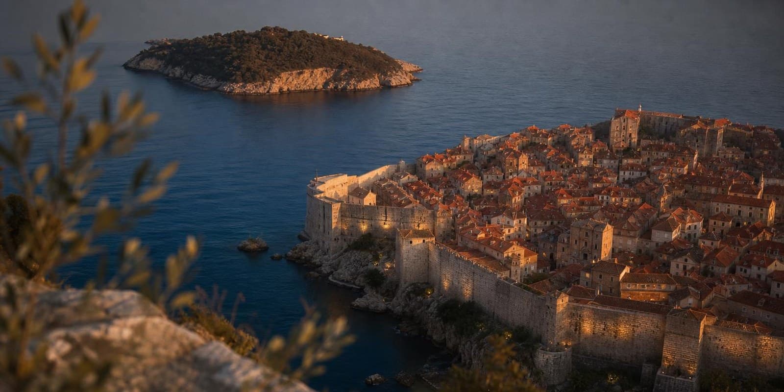 Festungsstadt Dubrovnik mit Ziegeldaechern und Stadtmauer am Abend ueber der Adria.