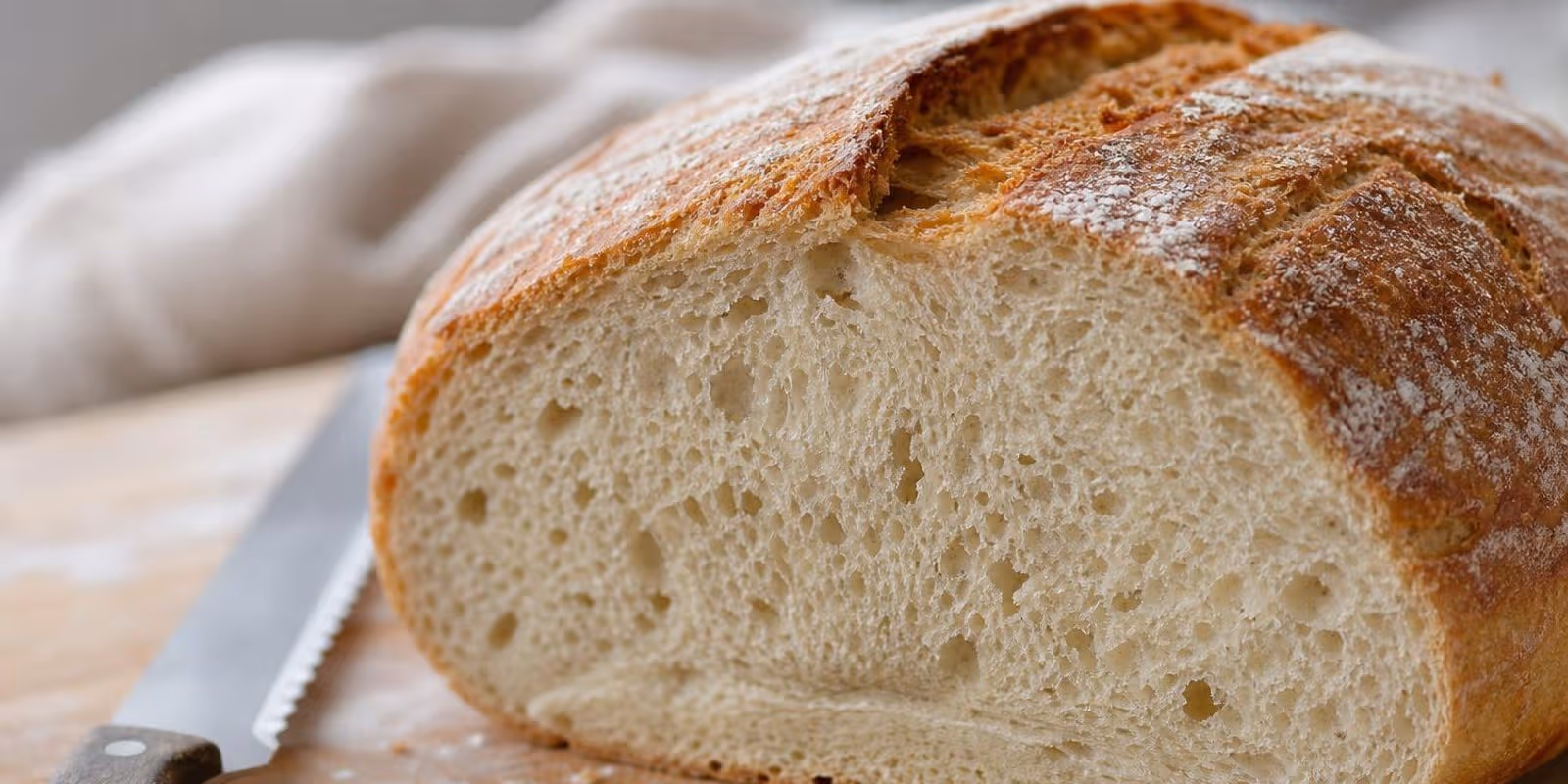 Aufgeschnittener Brotlaib zeigt im Anschnitt die Krume mit dichter Zone am Boden.