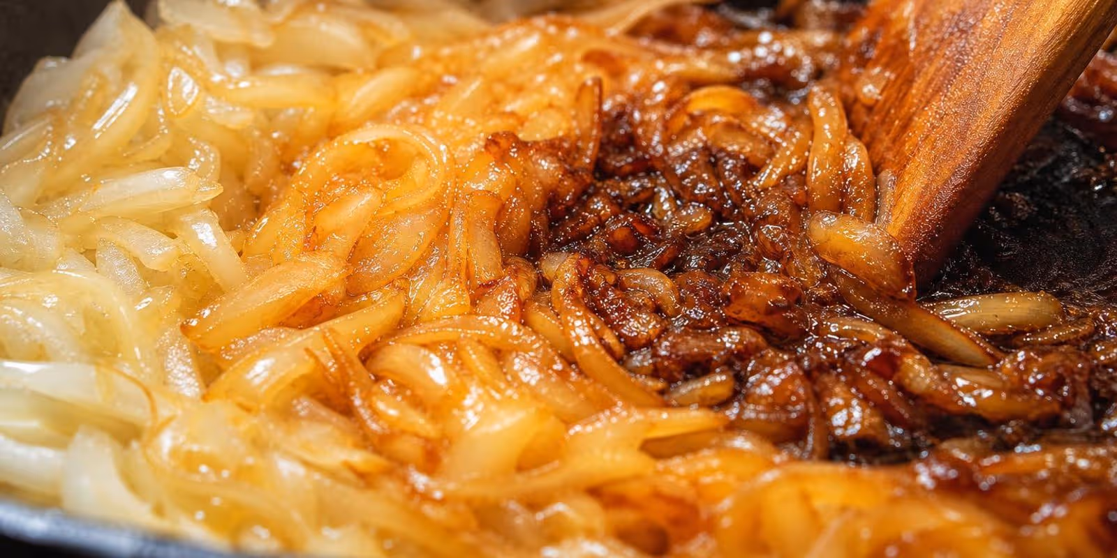 Zwiebelstreifen in der Pfanne, von glasig ueber goldbraun bis dunkel karamellisiert.