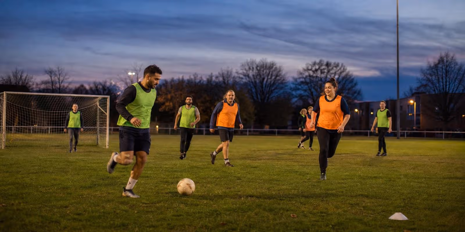 Gemischte Hobbytruppe spielt abends auf einem Amateurplatz ein kleines Trainingsspiel.