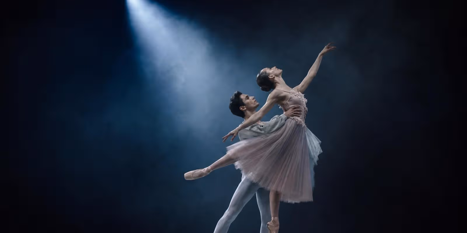 Aquarell: zwei Balletttaenzer in fliessender Bewegung im Lichtkegel der Buehne.