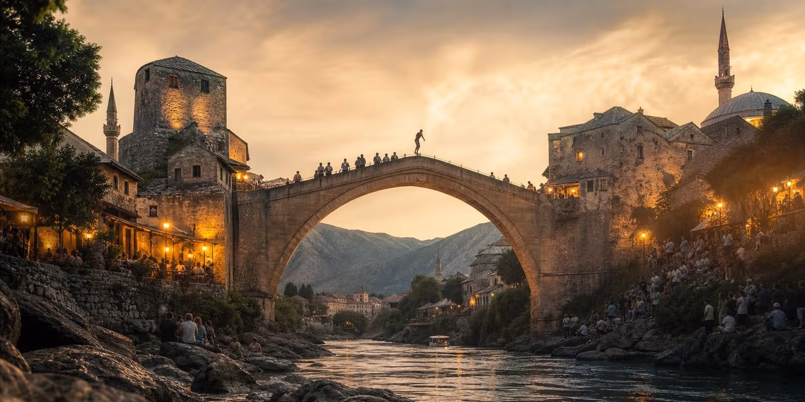 Die steinerne Bruecke Stari Most spannt sich hoch ueber die gruene Neretva in Mostars Altstadt.
