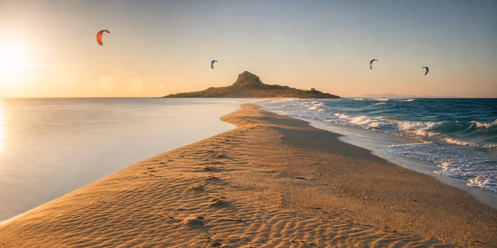 Schmale Sandzunge von Prasonisi trennt flaches Wasser und Wellen, auf beiden Seiten fliegen Kites.